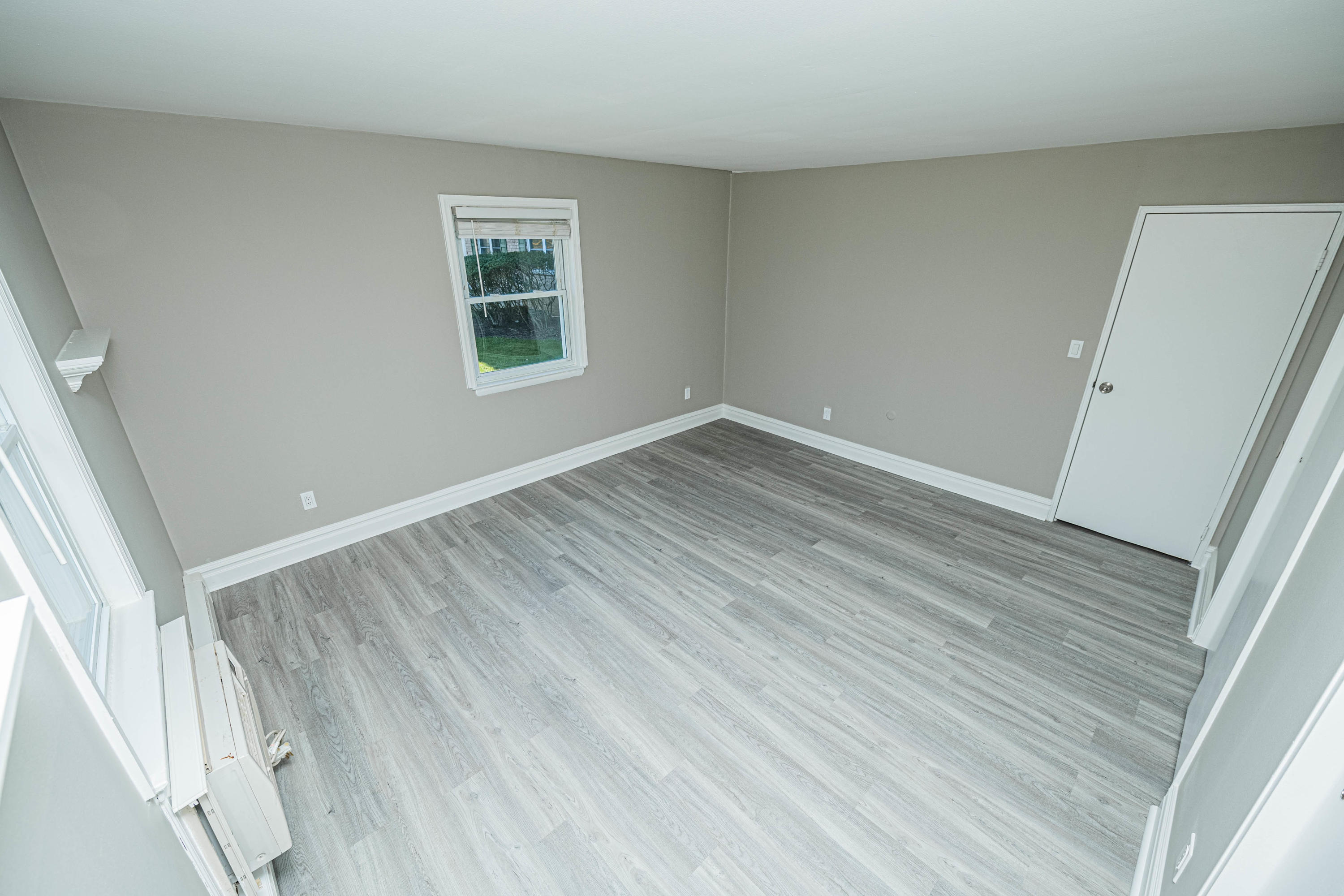 59 Stonehurst Boulevard, Unit B Freehold, NJ 07728 - Photo 19 of 25 an empty room with wooden floor and windows