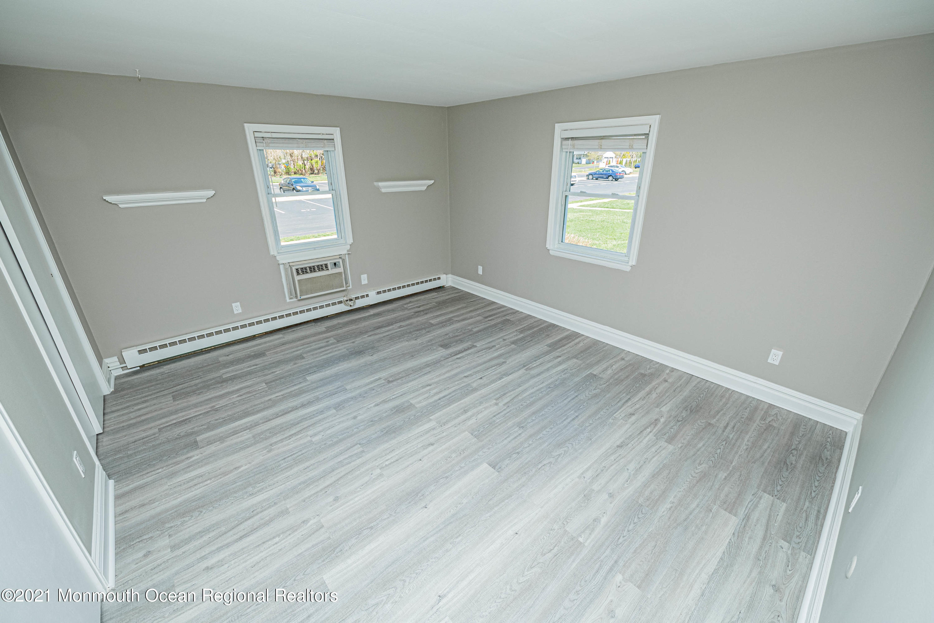 59 Stonehurst Boulevard, Unit B Freehold, NJ 07728 - Photo 21 of 25 a view of an empty room with a window and wooden floor
