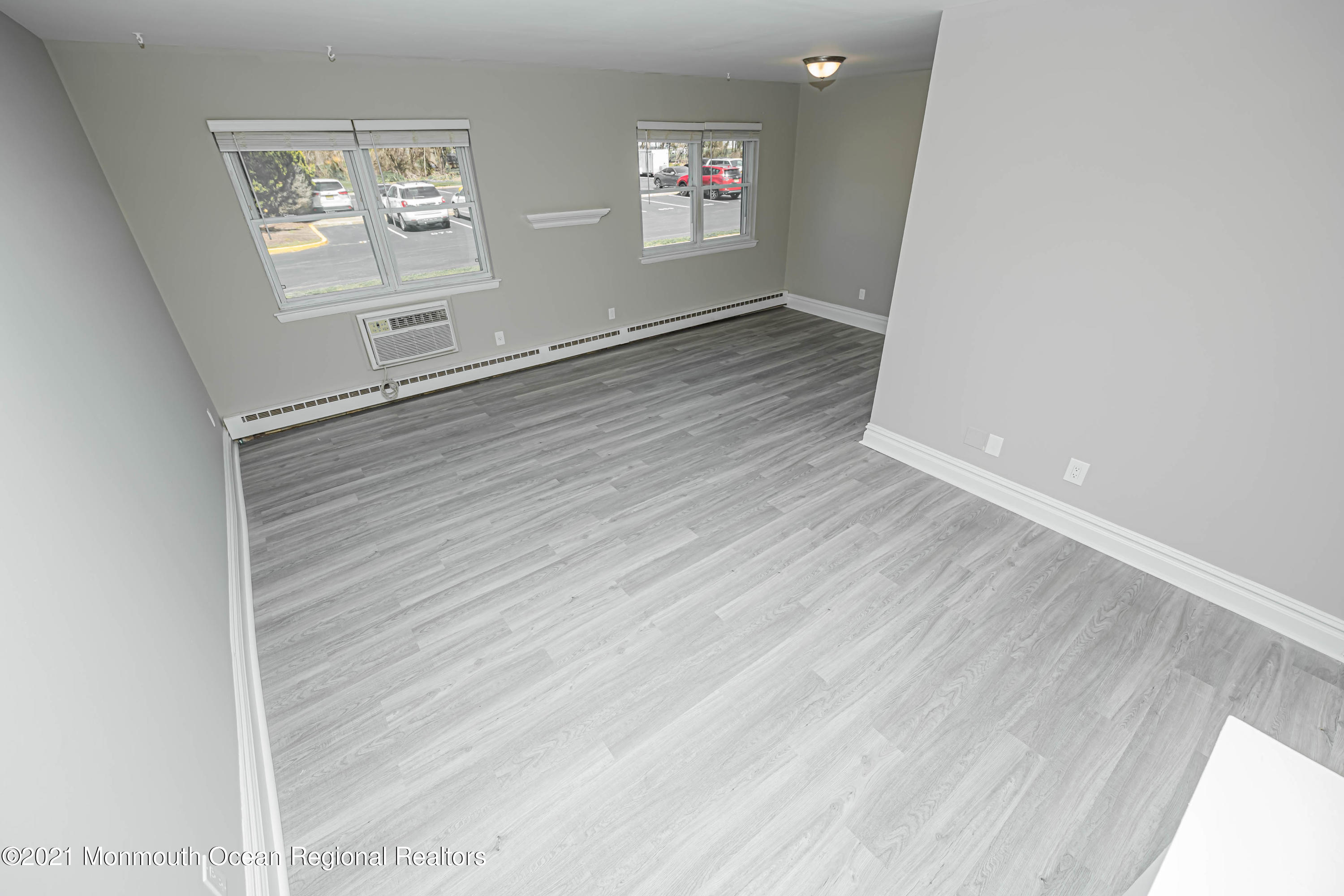 59 Stonehurst Boulevard, Unit B Freehold, NJ 07728 - Photo 9 of 25 a view of wooden floor and windows in an empty room