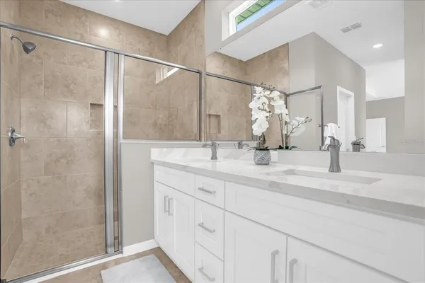 a bathroom with a double vanity sink mirror and shower