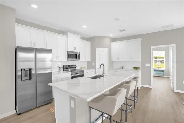a kitchen with refrigerator and chairs