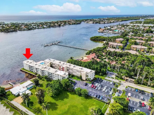 an aerial view of a house with a yard and lake view