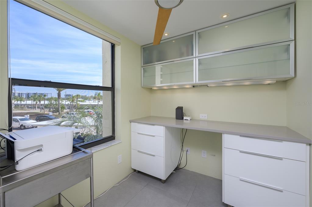 5780 Midnight Pass Road, Unit 210 Sarasota, FL 34242 - Photo 17 of 58 a room with a wooden floor and white cabinets
