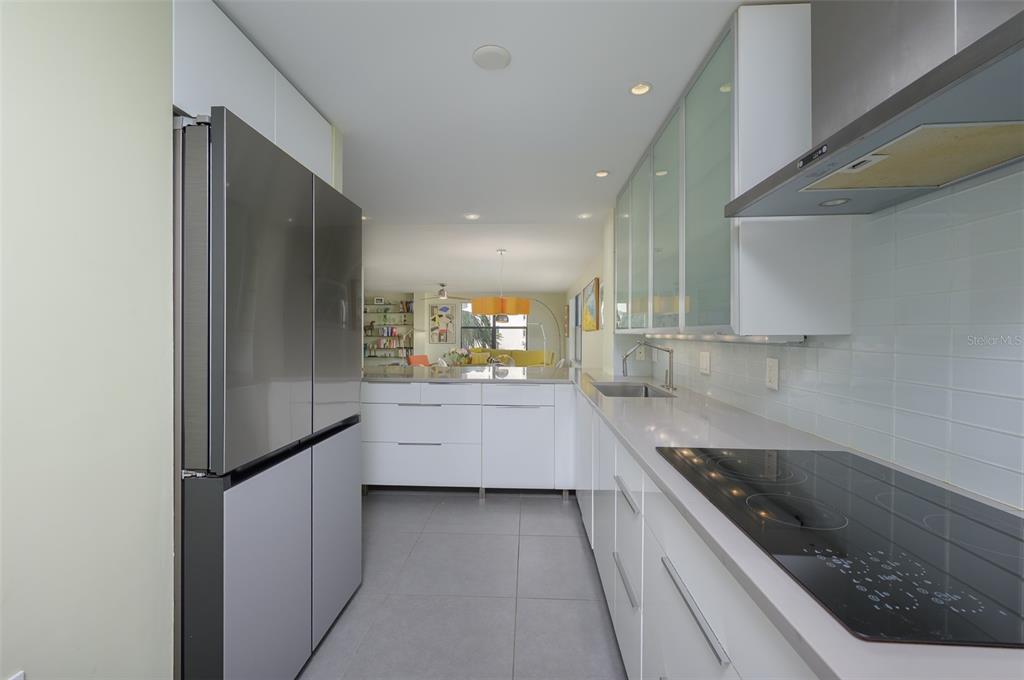 5780 Midnight Pass Road, Unit 210 Sarasota, FL 34242 - Photo 18 of 58 a large white kitchen with stainless steel appliances granite countertop a sink and a stove