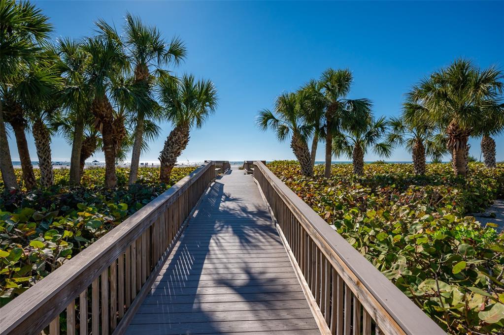 5780 Midnight Pass Road, Unit 210 Sarasota, FL 34242 - Photo 53 of 58 a view of balcony with wooden floor and palm trees