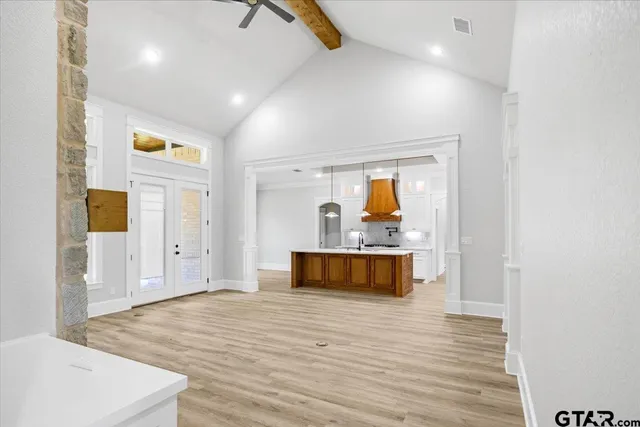 a view of an empty room with fireplace and wooden floor