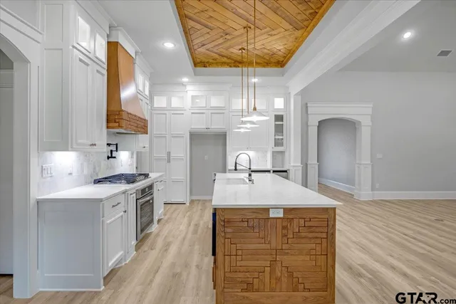 a kitchen with stainless steel appliances granite countertop a stove and a white cabinets