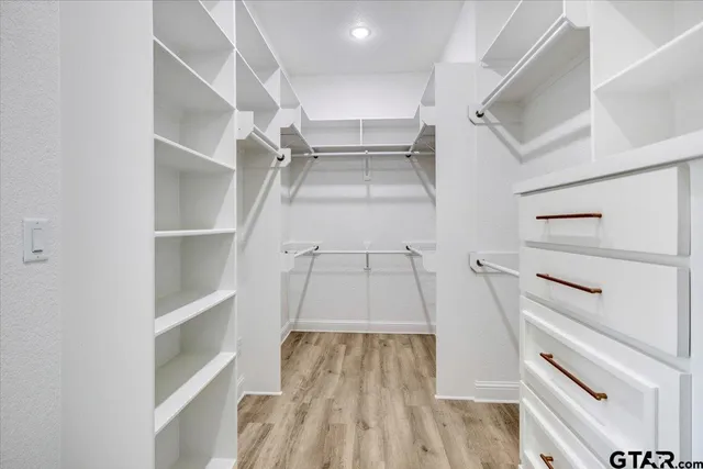 a view of walk in closet with empty racks