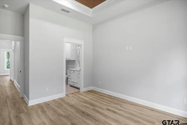 a view of an empty room with wooden floor and closet