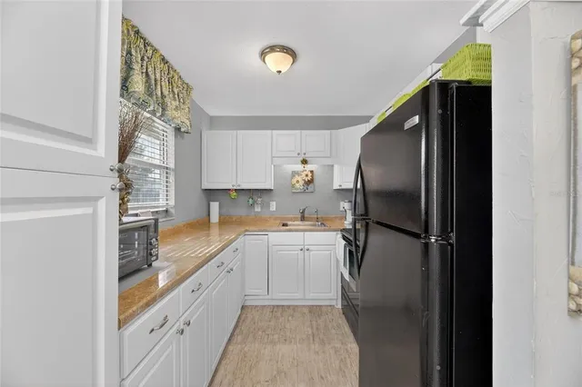 a kitchen with stainless steel appliances granite countertop white cabinets and a stove a sink