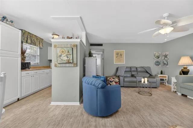 a living room with furniture a chandelier and a flat screen tv