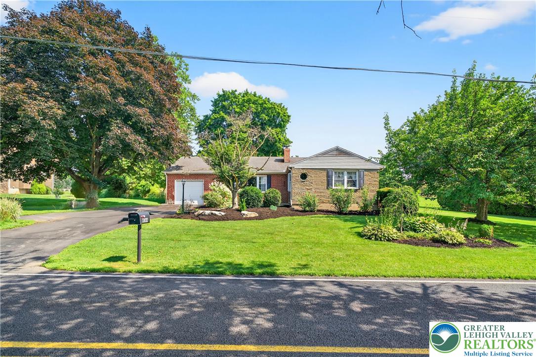 a front view of a house with a garden and trees