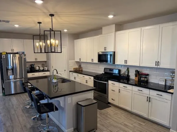 a kitchen with a sink a counter space appliances and cabinets