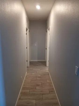 a view of a hallway with wooden floor