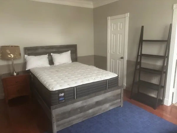 a living room with a bed and a dresser