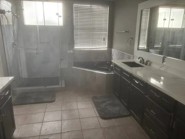 a bathroom with a granite countertop sink a toilet a bathtub and shower