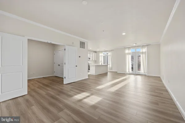 a view of an empty room with wooden floor