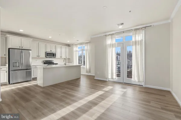 a kitchen with stainless steel appliances granite countertop a refrigerator sink and white cabinets
