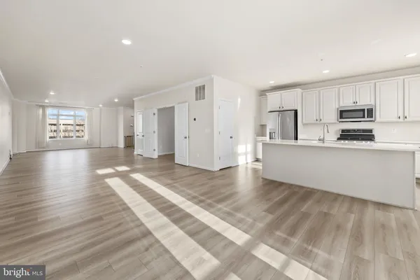 a view of a kitchen with a sink and dishwasher wooden floor