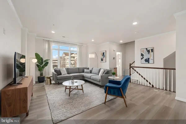 a living room with furniture a wooden floor and a flat screen tv