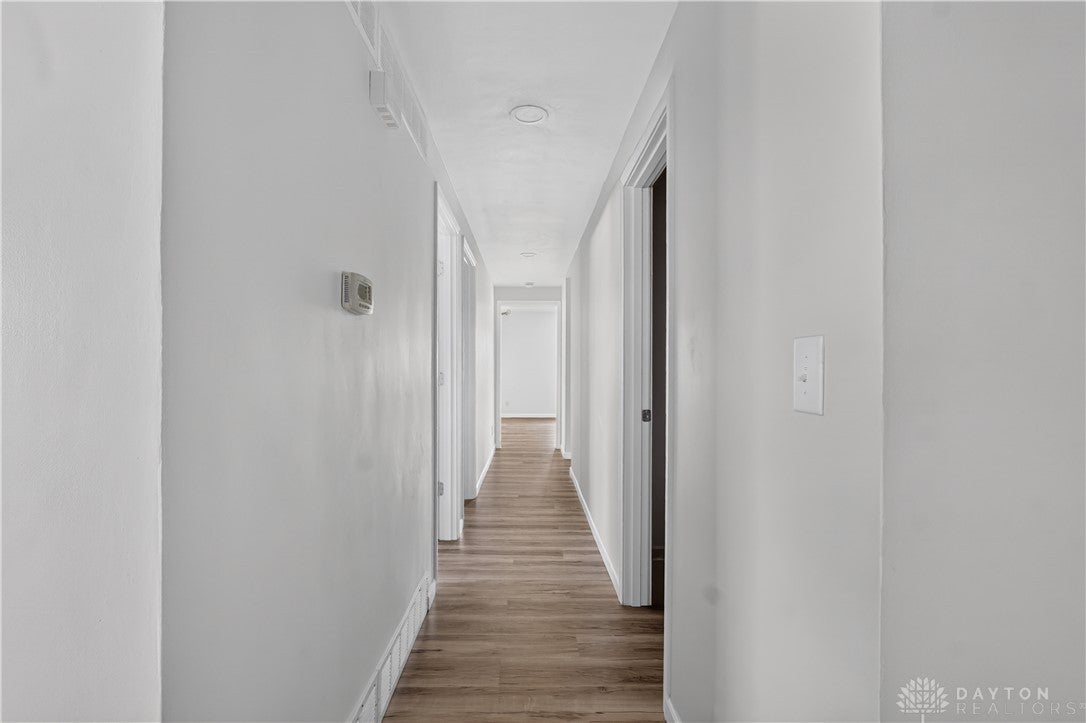 1243 Student Avenue Springfield, OH 45503 - Photo 15 of 38 Smooth wood-look flooring guides the eye through this clean-lined, modern central hallway.