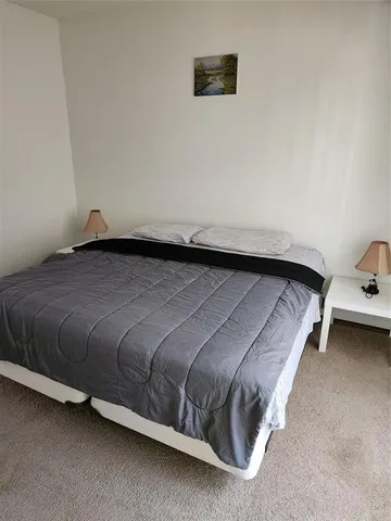 a bedroom with a bed and a night stand