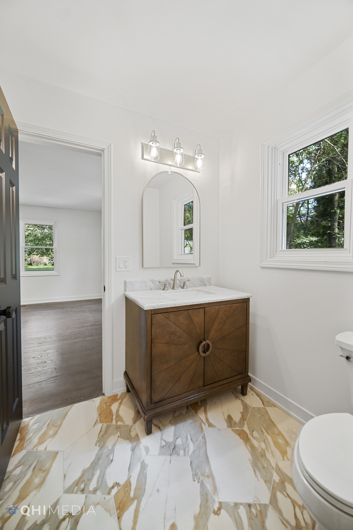1801 Orchard Road Wheaton, IL 60189 - Photo 20 of 41 a bathroom with a sink vanity granite toilet and a mirror