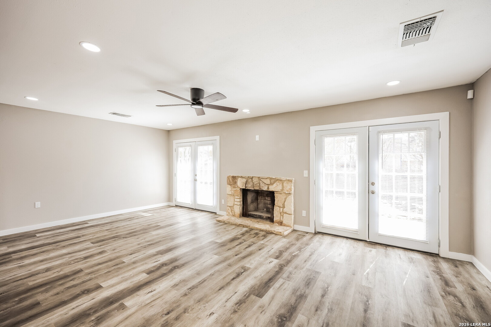 7030 Settlers Ridge Leon Valley, TX 78238 - Photo 5 of 19 an empty room with wooden floor fireplace and windows