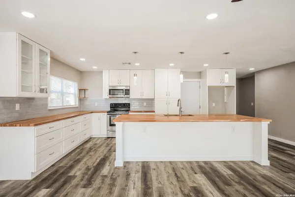 a large kitchen with stainless steel appliances kitchen island a large counter top and a stove top oven