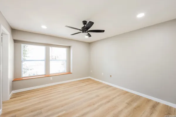 an empty room with a window and a ceiling fan