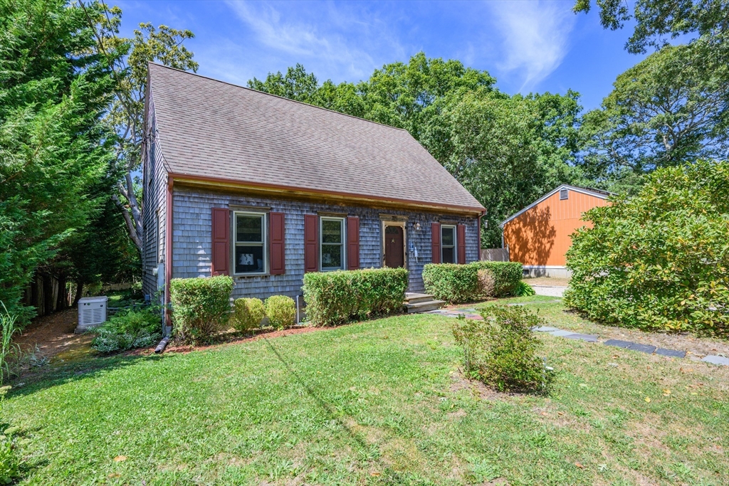 a aerial view of a house next to a big yard and large trees