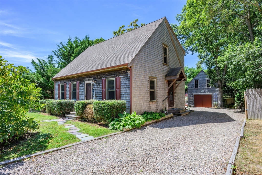 213 Hinckley Road Barnstable, MA 02601 - Photo 5 of 39 a front view of a house with a yard and garage