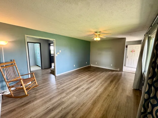 a view of a livingroom with wooden floor and a ceiling fan