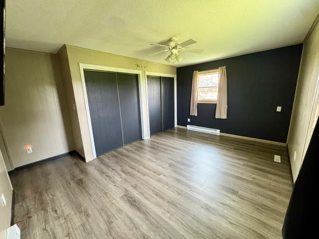 a view of a livingroom with wooden floor and window