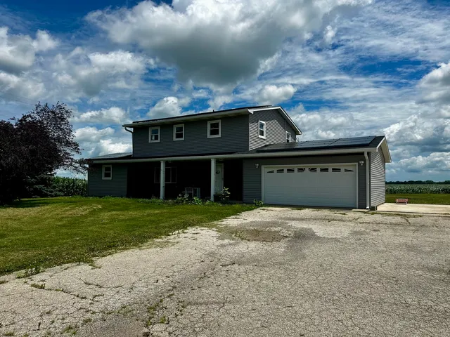 a front view of a house with a garden and yard