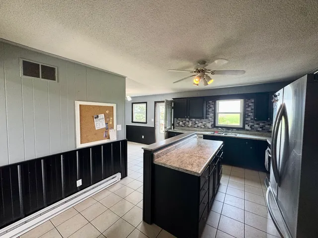 a kitchen with stainless steel appliances granite countertop a refrigerator a sink and dishwasher