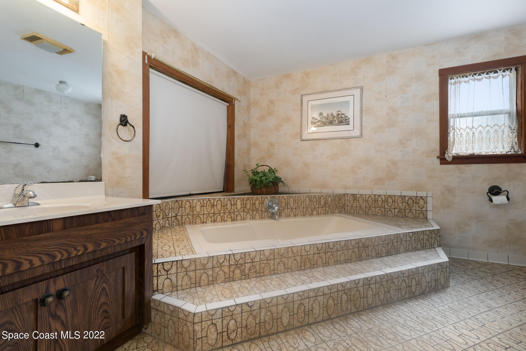 2187 Turtle Mound Road Melbourne, FL 32934 - Photo 22 of 42 a bathroom with a bathtub sink and mirror