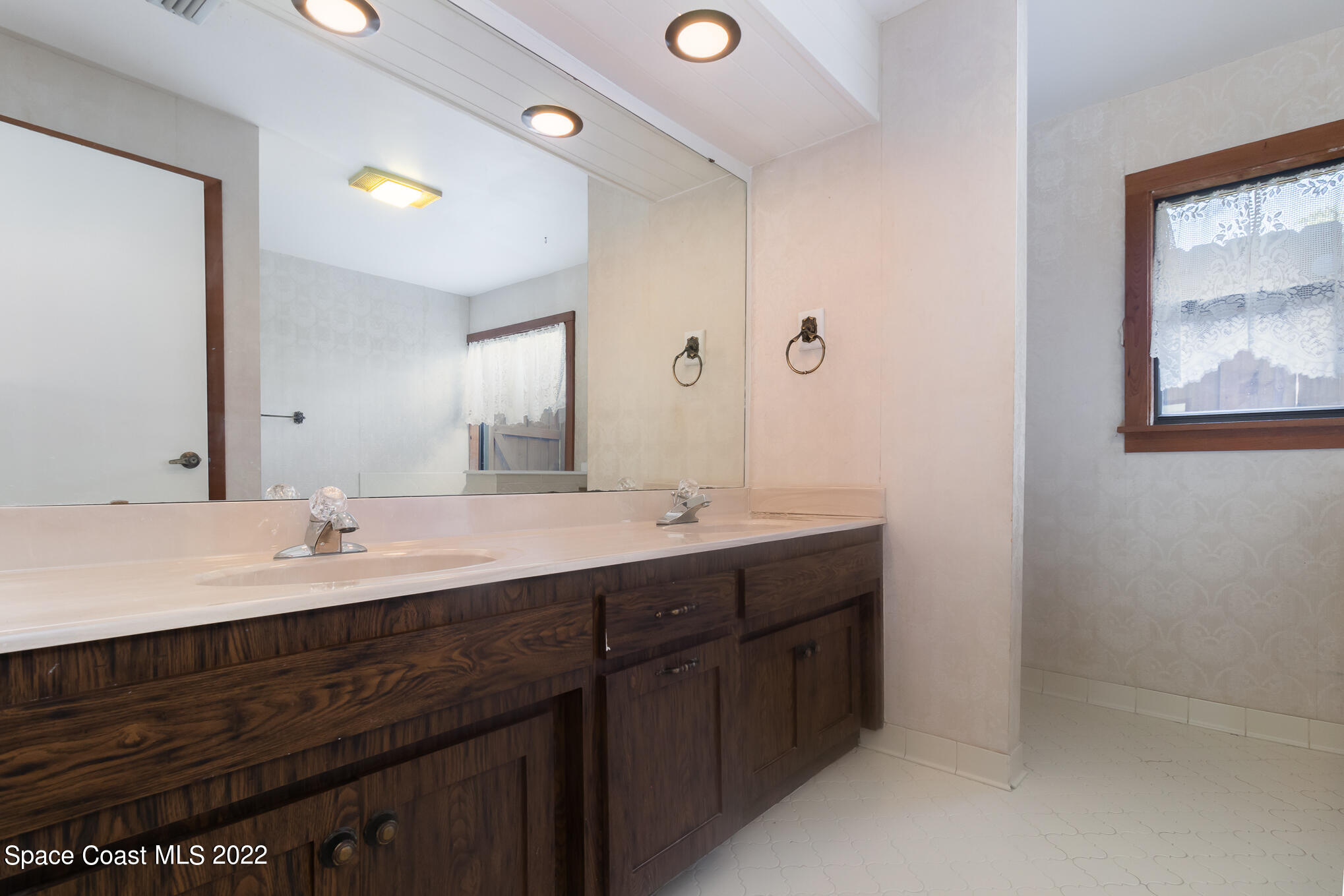 2187 Turtle Mound Road Melbourne, FL 32934 - Photo 29 of 42 a bathroom with a double vanity sink and a mirror