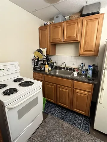 a kitchen with sink a stove and cabinets