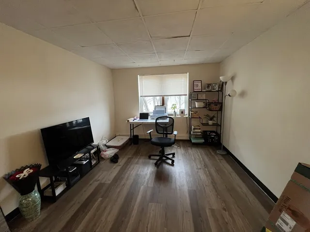a workspace with wooden floor and a window
