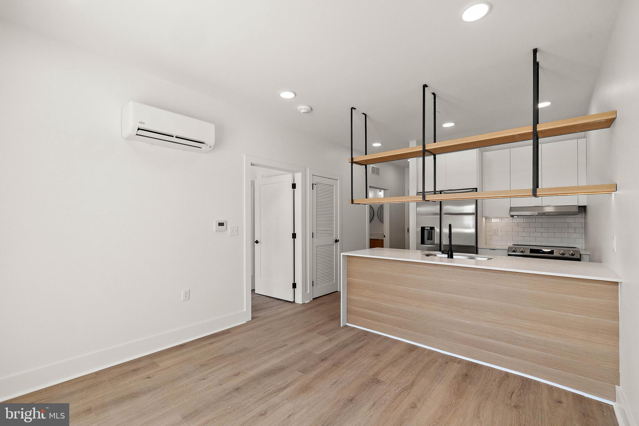 a view of kitchen with stainless steel appliances refrigerator and wooden floor