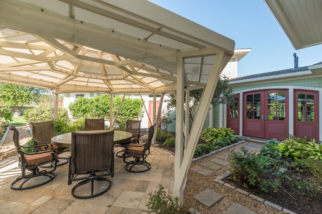 131 Atlantic Road Gloucester, MA 01930 - Photo 15 of 40 a view of a patio with table and chairs potted plants and floor to ceiling window