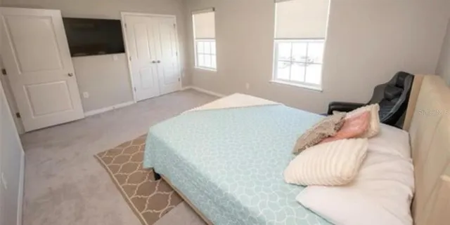a bedroom with a bed and flat screen tv