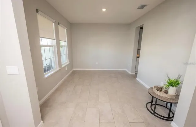 an empty room with windows and flower pot