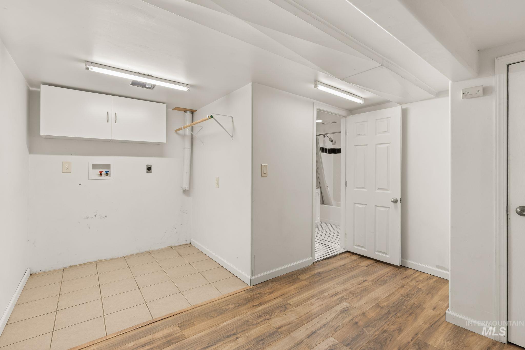 928 3rd Street Clarkston, WA 99403 - Photo 25 of 44 Dedicated laundry area featuring upper cabinetry, a hanging rack, and tile flooring
