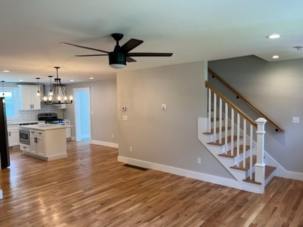 19 Indian Road, Unit B Groton, MA 01450 - Photo 15 of 27 a view of an empty room and kitchen with wooden floor