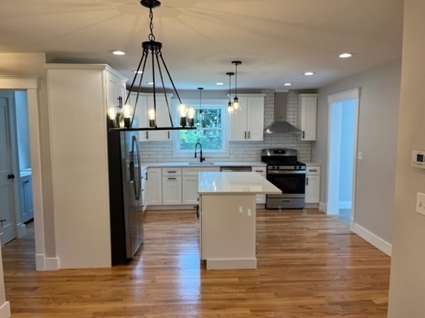 19 Indian Road, Unit B Groton, MA 01450 - Photo 3 of 27 a kitchen with stainless steel appliances kitchen island granite countertop a refrigerator a stove and a wooden floors
