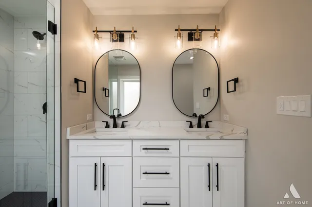 a bathroom with double vanity sinks and a mirror