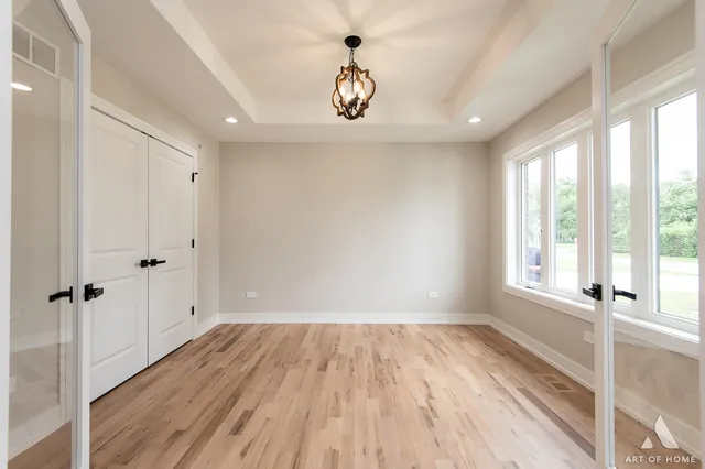 a view of a hallway with wooden floor and a window
