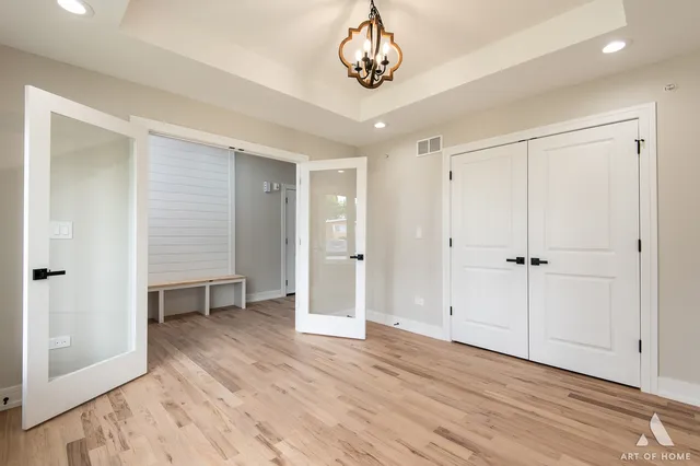 an empty room with wooden floor wooden door and windows